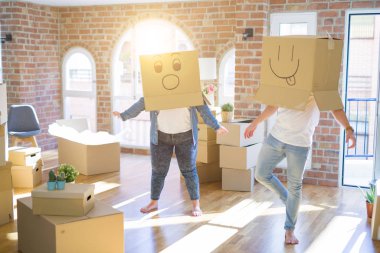 Komik emoji ile karton kutular giyen çılgın çift kafa üzerinde yüzler, yeni evde eğlenmek