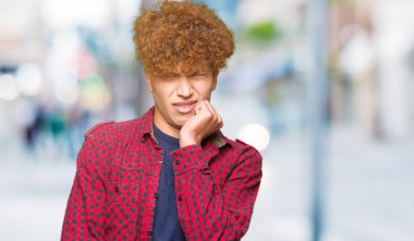 Stresli ve gergin elle çivi ısırma ağzına bakarak bir ceket afro saçlı Genç yakışıklı öğrenci adam. Anksiyete sorunu.