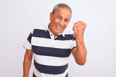 Üstün gri saçlı, sıradan çizgili polo giyen bir adam izole edilmiş beyaz arka planda öfkeli ve kızgın duruyor öfkeyle bağırırken yumruğunu kaldırıyor. Öfke ve agresif kavram.