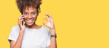 Genç Afro-Amerikan kadın parmakları, mükemmel sembolü olan ok işareti yapıyor izole arka plan üzerinde Smartphone'da söz