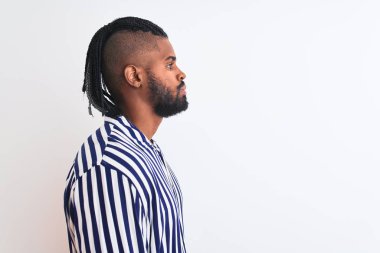 Siyah çizgili gömlekli Afro-Amerikan bir adam. İzole edilmiş beyaz bir arka planı var. Yan tarafa bakıyor, rahat poz veriyor..