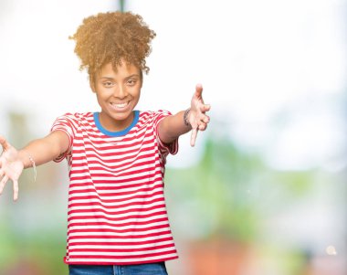 Sarılmak için kollarını açarak gülümseyerek kameraya bakarak izole arka plan güzel genç Afro-Amerikan kadın. Neşeli ifade kucaklayan mutluluk.