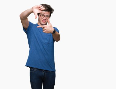 Elle yapma çerçeve ve parmakları ile mutlu yüz gülümseyen izole arka plan üzerinde gözlük takan yakışıklı delikanlı. Yaratıcılık ve Fotoğrafçılık kavramı.