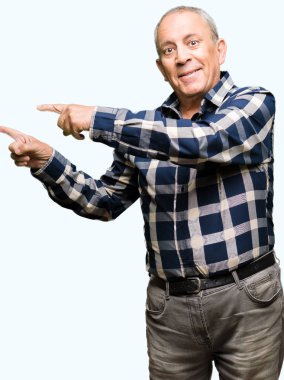 Yakışıklı komuta sizde rahat forması giyen gülümseyen ve iki elleri ve parmakları ile tarafına işaret kamera bakıyor.