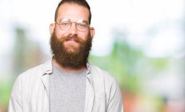 Genç sarışın adam gözlüklü eller birlikte ve parmakları rahat ve neşeli gülümseyen geçti. Başarı ve iyimser