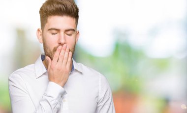 Genç yakışıklı iş adamı esneme yorgun kapsayan ağız el ile sıkılmış. Restless ve uyku hali.