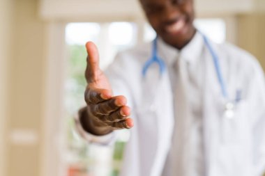 Bir Afrikalı doktor el hoş geldiniz el sallamak ve gülümseyen sunan yakın çekim