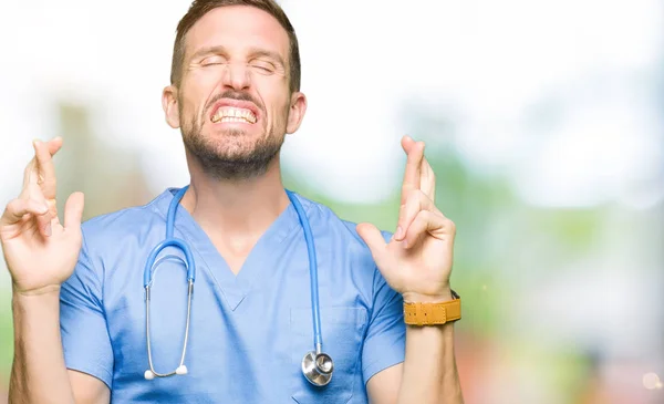 笑顔希望と目を閉じて交差指分離の背景に医療制服を着てハンサムな医者の男 運と迷信的な概念 — ストック写真