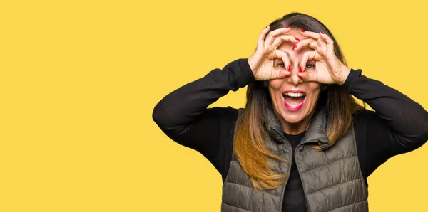 Beautiful Middle Age Woman Wearing Winter Vest Doing Gesture Binoculars — Stock Photo, Image