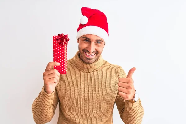 Genç Yakışıklı Adam Noel Şapkası Takıyor Arka Planda Hediyesini Tutuyor — Stok fotoğraf