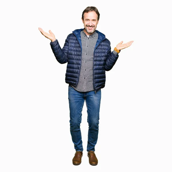 両手を見せて笑顔 手のひらを開くは 提示し 広告の比較やバランスの冬のコートを着て中年ハンサムな男 — ストック写真
