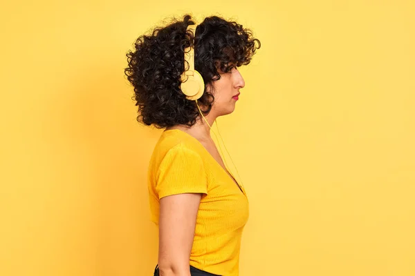 Арабская Женщина Вьющимися Волосами Слушать Музыку Помощью Наушников Изолированном Желтом — стоковое фото