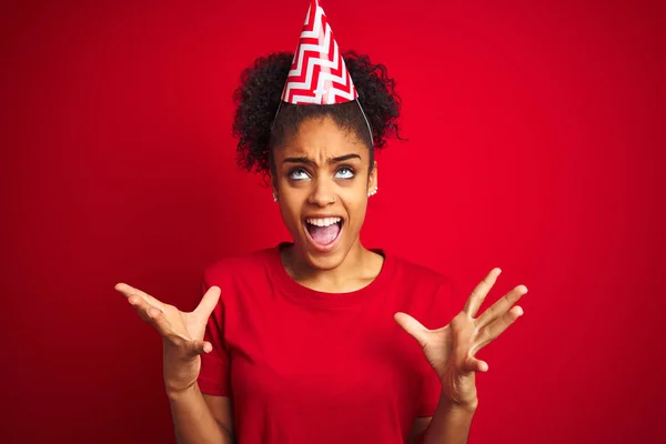 Jonge Afro Amerikaanse Vrouw Draagt Verjaardagshoed Geïsoleerde Rode Achtergrond Gek — Stockfoto