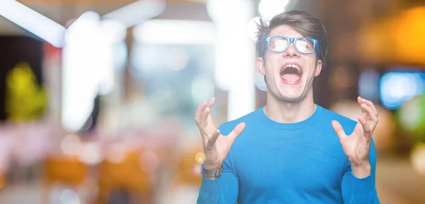 Joven Hombre Guapo Con Gafas Azules Sobre Fondo Aislado Loco —  Fotos de Stock