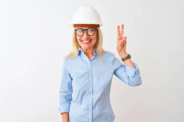 中年妇女建筑师 戴着眼镜和头盔 站在孤独的白色背景上 带着第二指尖 面带微笑 自信而快乐 — 图库照片
