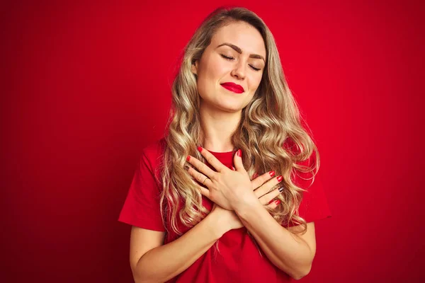 Mladá Krásná Žena Základním Tričku Stojí Nad Červeným Izolovaným Pozadím — Stock fotografie