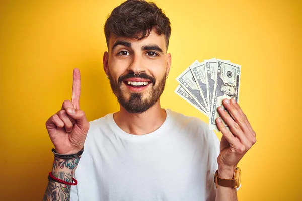 Joven Hombre Con Tatuaje Sosteniendo Dólares Pie Sobre Fondo Amarillo —  Fotos de Stock