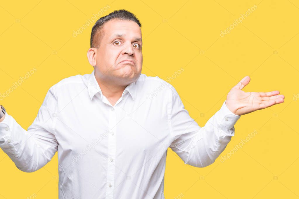 Middle age arab elegant man over isolated background clueless and confused expression with arms and hands raised. Doubt concept.