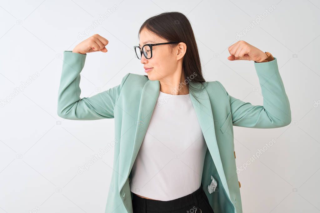 Chinese businesswoman wearing elegant jacket and glasses over isolated white background showing arms muscles smiling proud. Fitness concept.