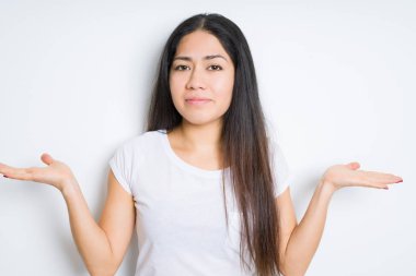 Güzel esmer kadın yüzünden izole arka plan clueless ve şaşkın bir ifadeyle kollar ve eller kaldırdı. Şüphe kavramı.