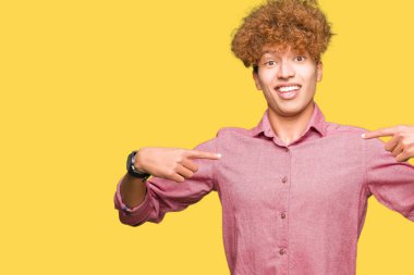 Afro saçlı genç yakışıklı iş adamı yüzünde gülümseme ile kendinden emin görünümlü, parmakları gururlu ve mutlu kendini işaret.