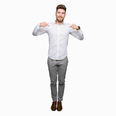 Yüzünde gülümseme ile kendinden emin görünüyorsun, kendini gururlu ve mutlu parmakları ile işaret genç yakışıklı iş adamı.