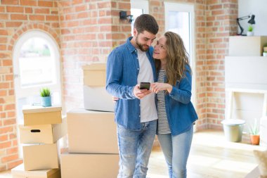 Genç çift cardb etrafında akıllı telefon kullanarak yeni bir eve hareket