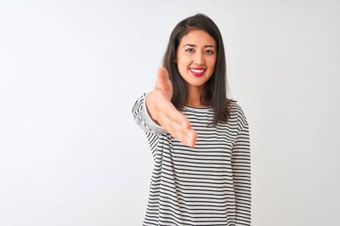 İzole edilmiş beyaz arka planda duran çizgili tişört giyen genç, güzel Çinli bir kadın dostça bir selamlama ve hoş geldin hediyesi olarak el sıkışmayı sunuyor. Başarılı bir iş..