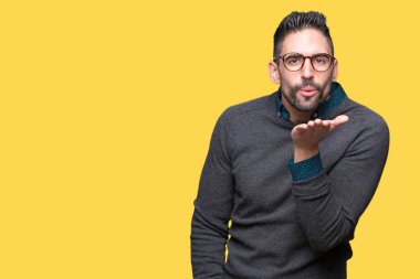 Bir öpücük el ile güzel ve seksi olmak hava üfleme kamera bakarak izole arka plan üzerinde gözlük takan yakışıklı delikanlı. Aşk ifade.
