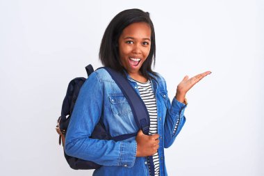 Afrika kökenli Amerikalı genç bir bayan sırt çantası takıyor çok mutlu ve heyecanlı, kazanan ifade zaferi büyük bir gülümsemeyle kutluyor ve ellerini kaldırıyor