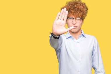 Afro giyen gözlük ile genç yakışıklı iş adamı el avuç ile şarkı durdurmak yapıyor. Yüz üzerinde negatif ve ciddi jest ile uyarı ifadesi.