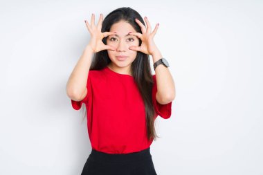 Güzel esmer kadın izole edilmiş arka planda kırmızı tişört giyiyor parmaklarıyla gözlerini açmaya çalışıyor, uykulu ve yorgun sabah yorgunluğu için.