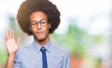 Genç Afro-Amerikan iş Waiving Merhaba mutlu afro saçlı gözlüklü adam ve gülümseyen, dostça jest hoş geldiniz