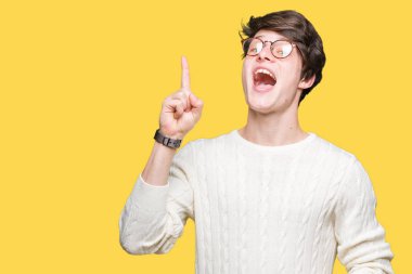 Başarılı fikirle izole arka plan işaret parmağı üzerinde gözlük takan yakışıklı delikanlı. Çıktıktan ve mutlu. Bir numara.