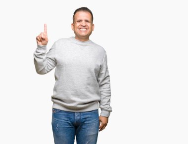 Ve kendinden emin ve mutlu gülümseyerek süre parmak numaralı yukarıyı gösteren izole arka plan üzerinde spor kazak giyen orta yaş Arap adam.