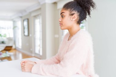 Afro saçlı güzel genç afro-amerikan kadın yan bakıyor, kendine güvenen gülümseme ile doğal yüzü ile profil poz dinlenmek.