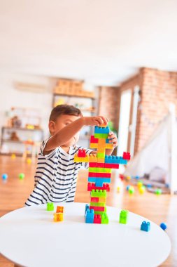 Güzel çocuk anaokulunda inşaat bloklarıyla oynuyor.