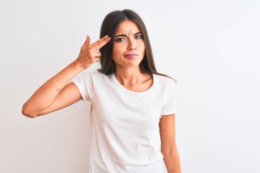 Genç, güzel bir kadın, izole edilmiş beyaz arka planda duran sıradan bir t-shirt 'le kendini vuruyor ve öldürüyor. Silah gibi el ve parmaklarını işaret ediyor, intihar jesti..