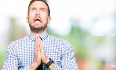 Yakışıklı iş adamı yalvarıyor ve umut ifade yüzünde çok duygusal ve endişe ile birlikte elleriyle dua kravat takıyor. Bağışlanmak. Din kavramı.