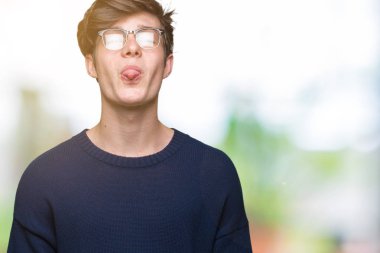 Genç yakışıklı adam gözlük dilini izole arka plan üzerinde mutlu komik ifade ile dışarı. Duygu kavramı.