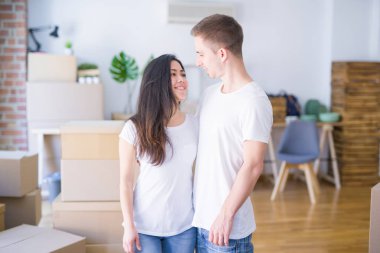 Karton kutuların etrafında duran genç ve güzel bir çift.