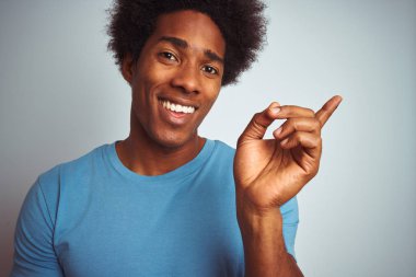 Afro saçlı, mavi tişörtlü, izole edilmiş beyaz arka planda duran Afro-Amerikan bir adam.