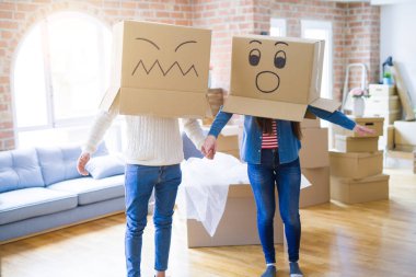 Çılgın çift kafa üzerinde komik yüzler ile kutuları giyiyor, yeni bir eve taşımak için mutlu eğlenceli