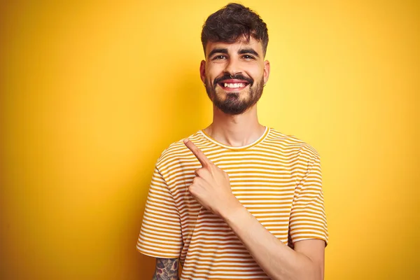 Mladý Muž Tetováním Sobě Pruhované Tričko Stojí Nad Izolovaným Žlutým — Stock fotografie