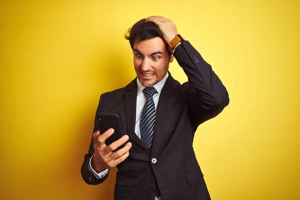 Młody Przystojny Biznesmen Korzystający Smartfona Stojącego Nad Odizolowanym Żółtym Tłem — Zdjęcie stockowe