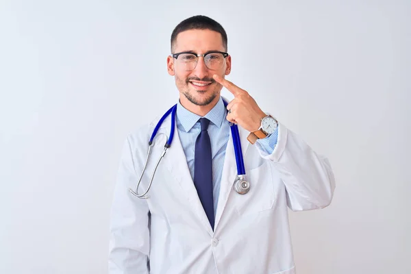 Młody Lekarz Noszący Stetoskop Odosobnionym Tle Wskazujący Palcem Twarz Nos — Zdjęcie stockowe
