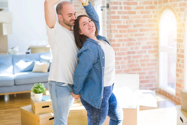Junges Paar Tanzt Neuen Zuhause Kartons Herum Und Feiert Lächelnd — Stockfoto