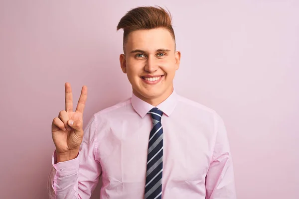 年轻英俊的商人穿着衬衫 打着领带 站在孤立的粉色背景上 带着自信和快乐的笑容 用手指指了指二号 — 图库照片