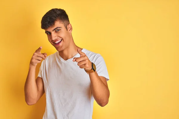 年轻的印度男子穿着白色的T恤 站在孤立的黄色背景上 手指指向镜头 脸上洋溢着欢乐和滑稽的表情 好的能量和活力 — 图库照片