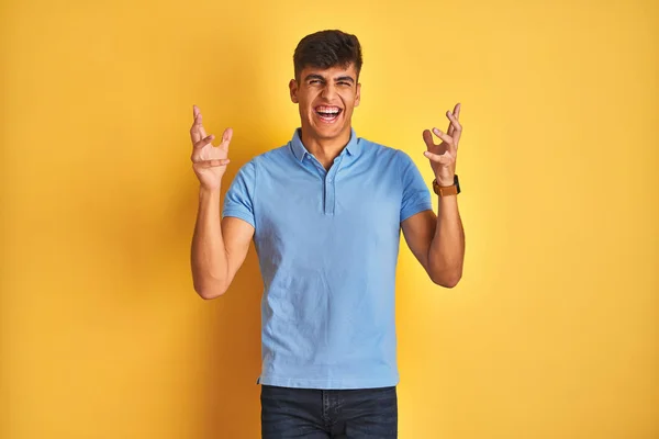 Homem Indiano Jovem Vestindo Pólo Azul Sobre Fundo Amarelo Isolado — Fotografia de Stock